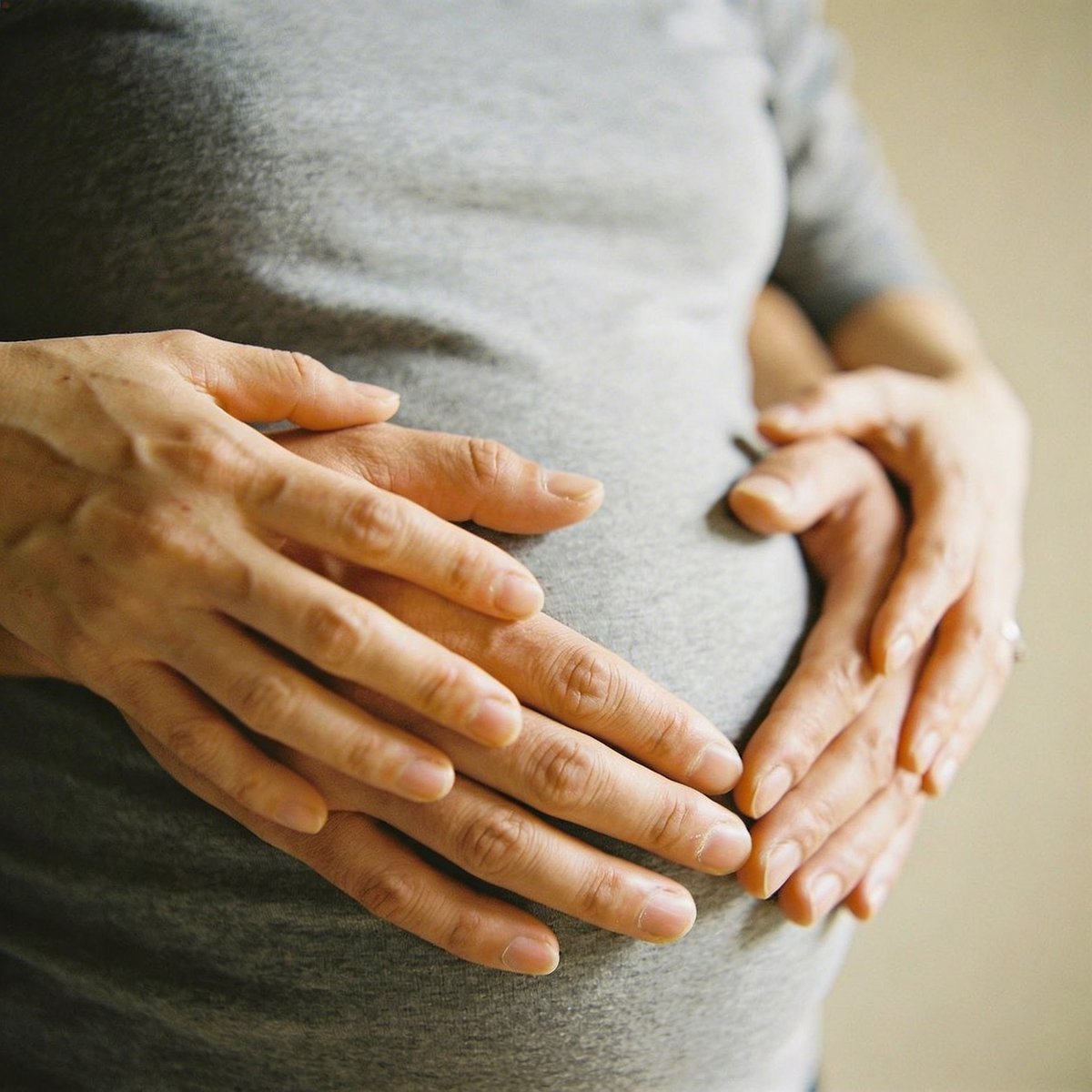 Handen op de buik van een zwangere vrouw, hartelijk moment